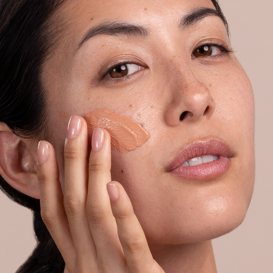 woman putting Eminence Organics Acne Advanced Clarifying Masque on her face