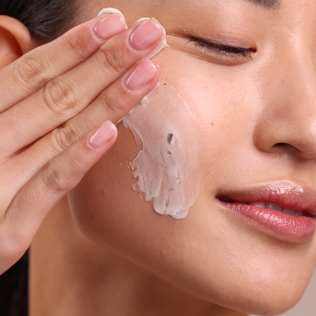 Close-up of a person applying Eminence Organics Bamboo Age Corrective Masque to their face