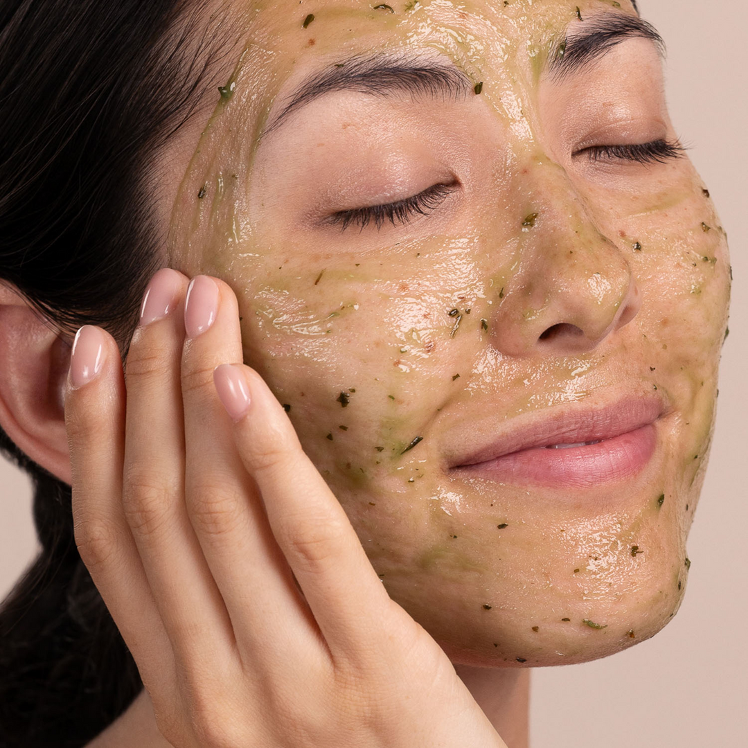 Woman applying a Eminence Organics Eight Greens Phyto Masque - Not Hot on her face