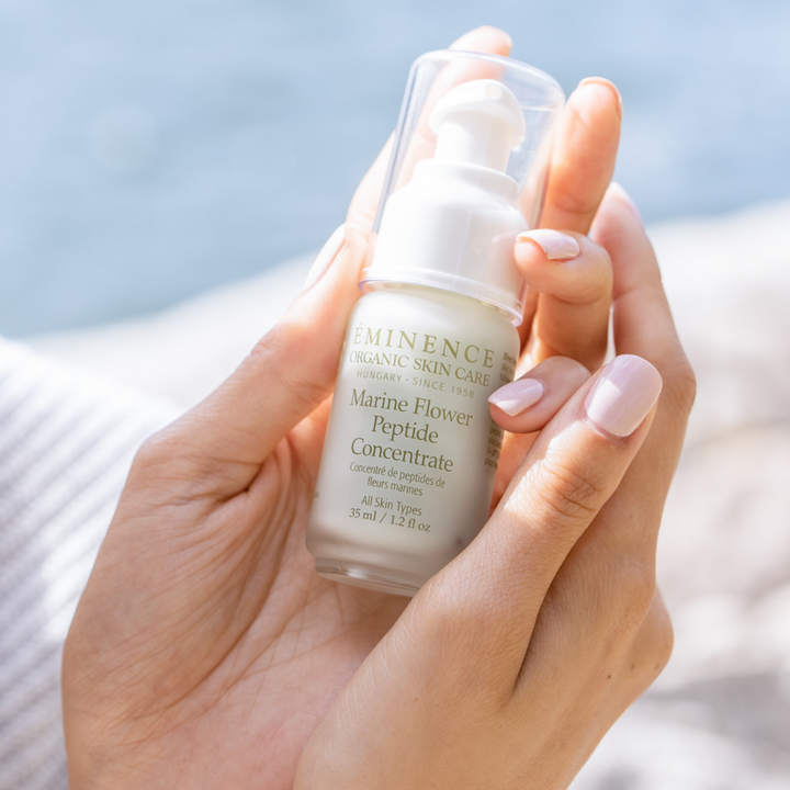 woman holding Eminence Organics Marine Flower Peptide Concentrate in her hand