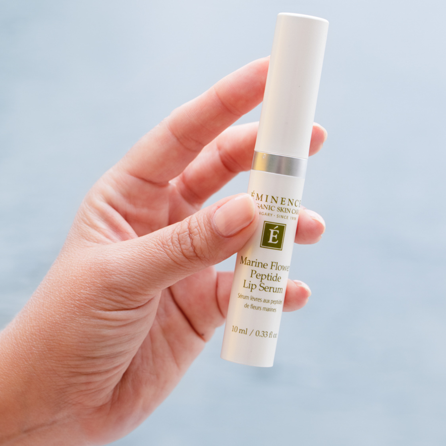 woman holding Eminence Organics Marine Flower Peptide Lip Serum in her hand