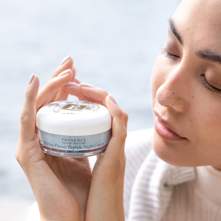 woman holding Eminence Organics Marine Flower Peptide Night Cream in her hands