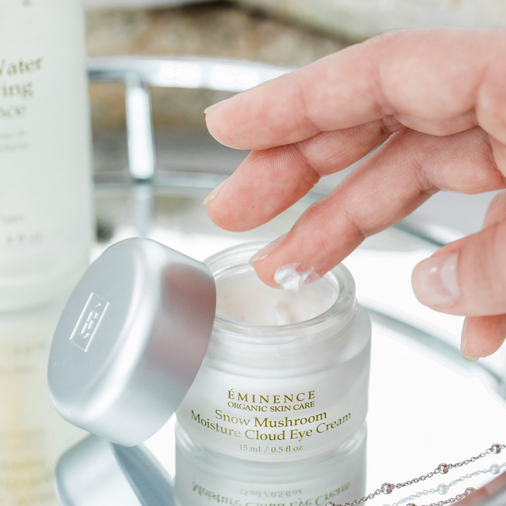 hand touching Eminence Organics Snow Mushroom Moisture Cloud Eye Cream 