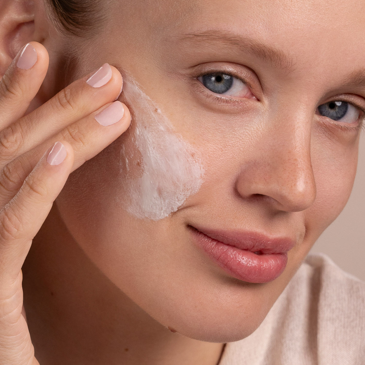 woman applying Eminence Organics Snow Mushroom &amp; Reishi Masque to her face