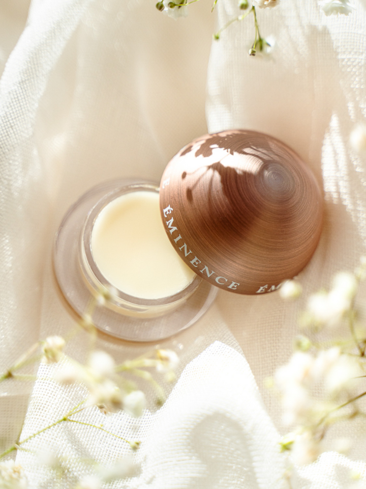 Eminence Organics Citrus Lip Balm on a soft fabric background